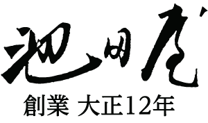 黒の日本の書道で、その下に小さな文字が添えられています。文字は様式化され、太字になっています。下の文字は日付の参照のようです。背景は白です。.