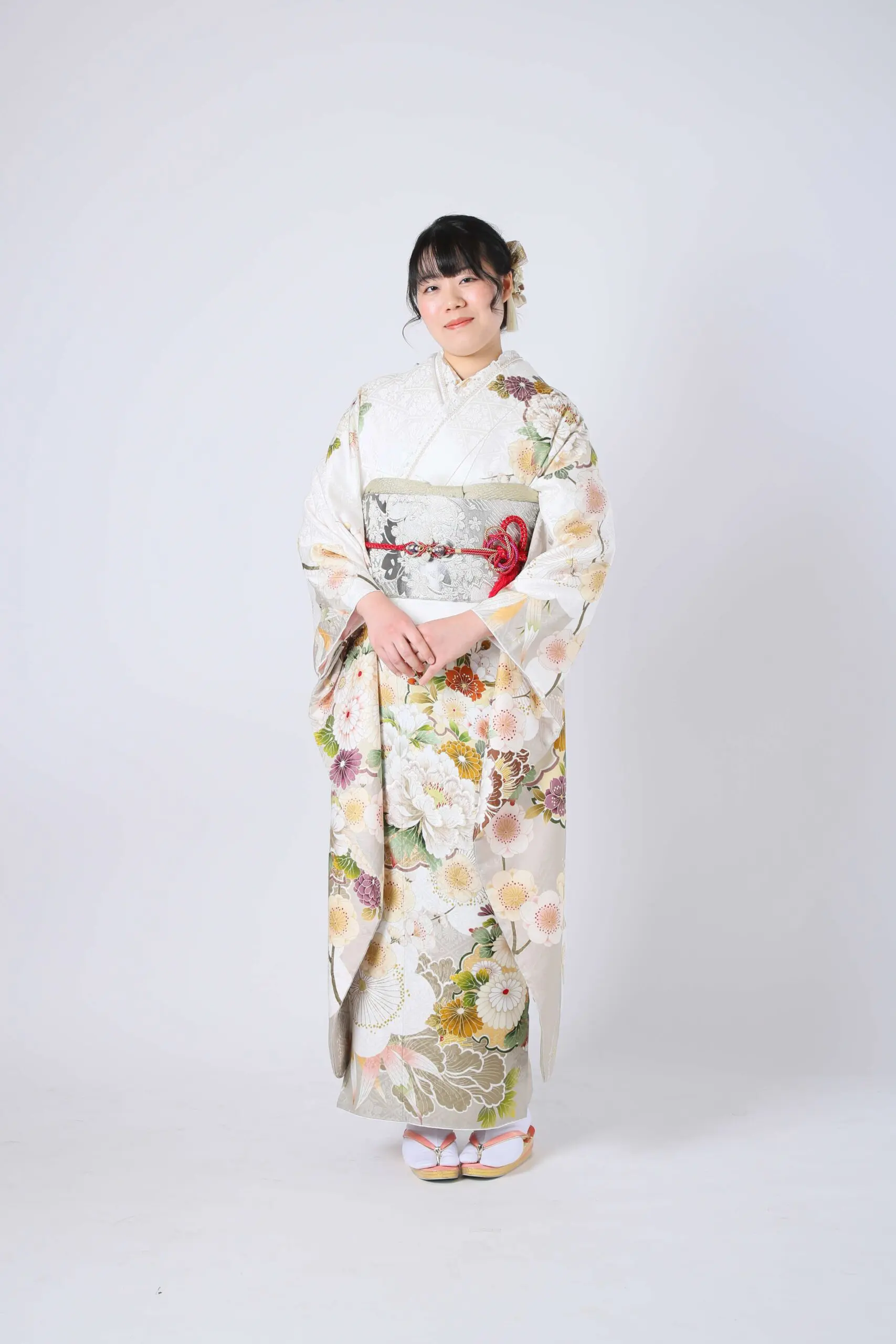 無地の背景に、花柄と装飾的な帯が特徴的な、「令和7年成人式、川口市」の着物を着ている人物が描かれています。彼らはサンダルと花柄の髪飾りでアクセサリーを付けています。.